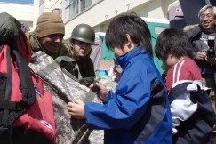 Photo : Children receive bags of friendship at the Minato Elementary School shelter.