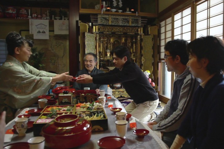 A family enjoys a typical new year’s feast. Small saucers of toso (spiced sake, said to drive off ill luck) are here being served to accompany the new year’s spread known as osechi ryori, an exquisitely arranged combination of seasonal foods.