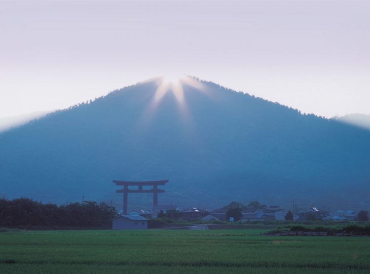 The sun rises over the summit of sacred Mt. Miwa. The otorii in the foreground is the gateway to Omiwa Jinja in Sakurai City, Nara Prefecture, one of the oldest extant Shinto shrines. (PHOTO: Courtesy of Omiwa Jinja)